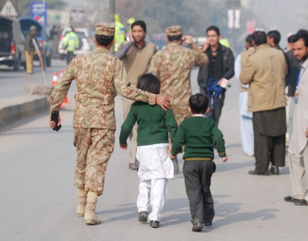 A soldier escorts schoolchildren after they were rescued from the Army Public School that is under attack by Taliban gunmen in Peshawar, December 16, 2014 A soldier escorts schoolchildren after they were rescued from the Army Public School that is under attack by Taliban gunmen in Peshawar, December 16, 2014 - Sputnik International