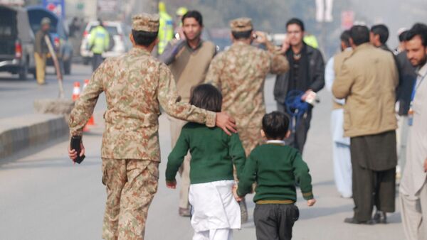 A soldier escorts schoolchildren after they were rescued from the Army Public School attacked by Taliban gunmen in Peshawar. - Sputnik International