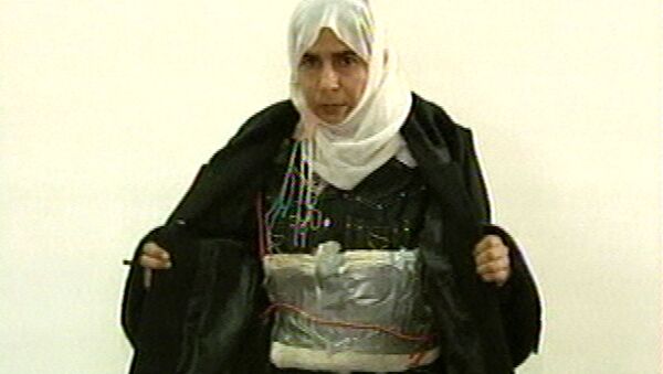 This image made from television shows Iraqi Sajida Mubarek Atrous al-Rishawi opening her jacket and showing an explosive belt - Sputnik International