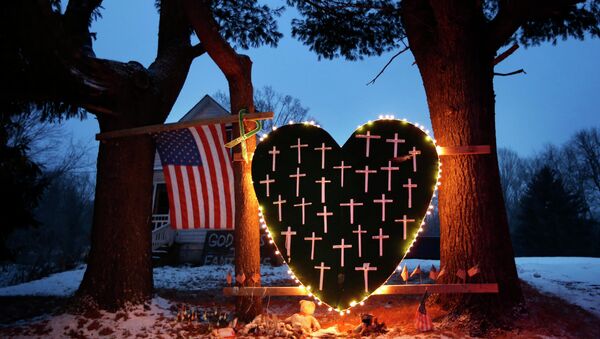 In this Dec. 14, 2013 file photo, a makeshift memorial with crosses for the victims of the Sandy Hook Elementary School shooting massacre stands outside a home in Newtown, Conn., on the one-year anniversary of the shootings. - Sputnik International
