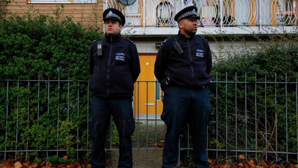 Police stand guard outside a South London - Sputnik International