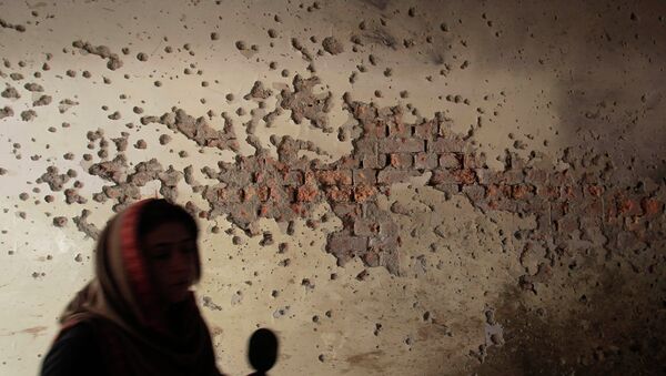 A local reporter walks past a damaged wall - Sputnik International