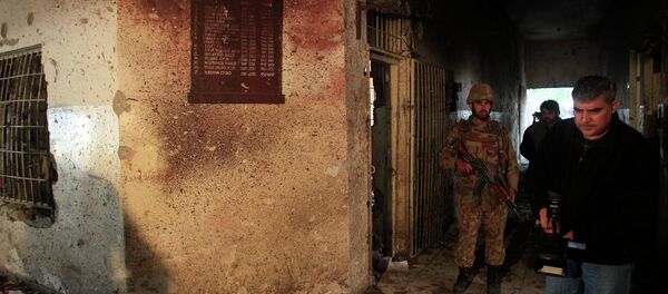 A local cameraman films in front of an army soldier at the Army Public School, which was attacked by Taliban gunmen, in Peshawar, December 17, 2014. - Sputnik International