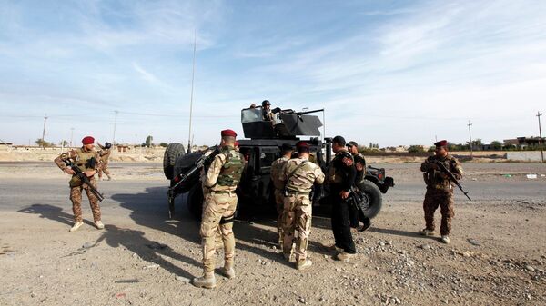 Members of the Iraqi security forces carrying their weapons . - Sputnik International