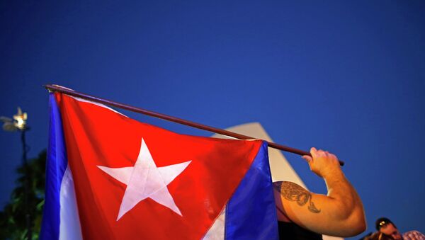 An anti-Castro Cuban exile holds a Cuban flag during a protest after the announcement of restoring diplomatic ties between Cuba and United States, at an area knows as 'Little Havana' in downtown Miami, Florida December 17, 2014. - Sputnik International