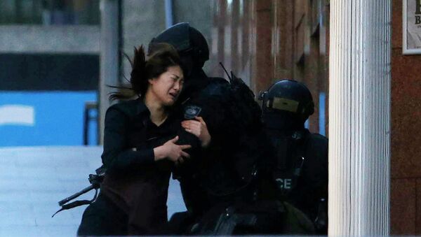 A hostage runs towards a police officer outside Lindt cafe, where other hostages are being held, in Martin Place in central Sydney - Sputnik International