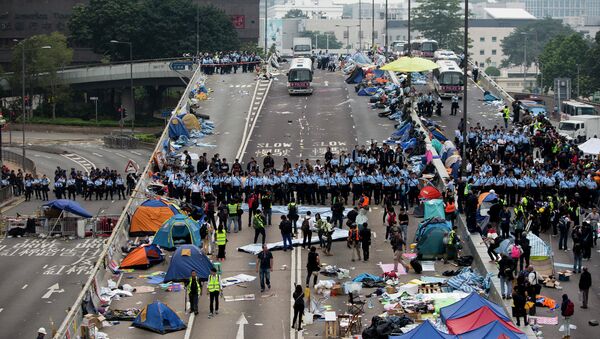 Police officers stand in a line as they prepare to clear tents outside Hong Kong's Government complex in Hong Kong - Sputnik International