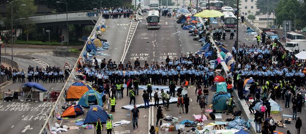 Police officers stand in a line as they prepare to clear tents outside Hong Kong's Government complex in Hong Kong Police officers stand in a line as they prepare to clear tents outside Hong Kong's Government complex in Hong Kong - Sputnik International