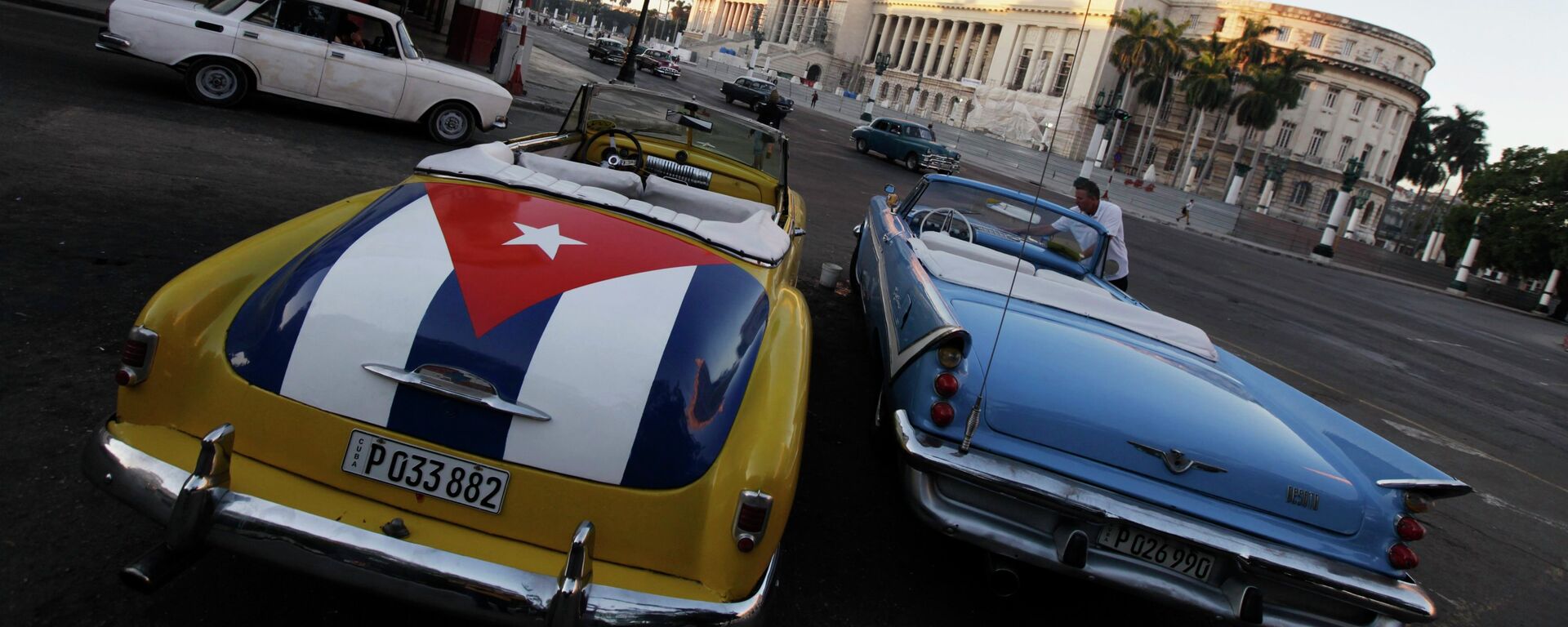 A car with a Cuban flag is parked near Cuban Capitol in Havana December 18, 2014. Cuban President Raul Castro hailed a landmark exchange of prisoners with the United States on Wednesday and praised U.S. President Barack Obama as the two countries agreed to normalize relations after more than five decades of hostility - Sputnik International, 1920, 05.11.2021