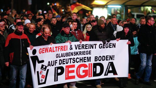 Participants hold a banner during a demonstration called by anti-immigration group PEGIDA, a German abbreviation for Patriotic Europeans against the Islamization of the West, in Dresden December 15, 2014. Several thousands opponents of Germany's policy towards asylum seekers and Islam took part in the protest in the eastern German town on Monday. The banner reads, Peaceful and united against wars of religion in Germany! - Sputnik International