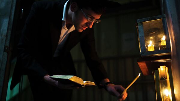 An ultra-Orthodox Jewish man lights a candle. - Sputnik International