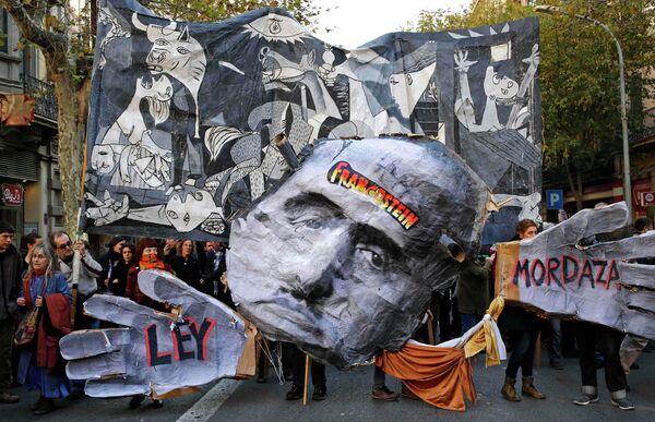 Demonstrators hold a banner featuring a painting of Pablo Picaso's The Guernica (back) and a cut-out of former Spanish dictator Francisco Franco (C), during a protest against the Spanish government's new anti-protest security law in Barcelona December 20, 2014. - Sputnik International