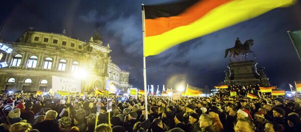 Participants hold German national flags during a demonstration organised by anti-immigration group PEGIDA, a German abbreviation for Patriotic Europeans against the Islamisation of the West, outside Semperoper opera house in Dresden December 22, 2014. Participants hold German national flags during a demonstration organised by anti-immigration group PEGIDA, a German abbreviation for Patriotic Europeans against the Islamisation of the West, outside Semperoper opera house in Dresden December 22, 2014. - Sputnik International