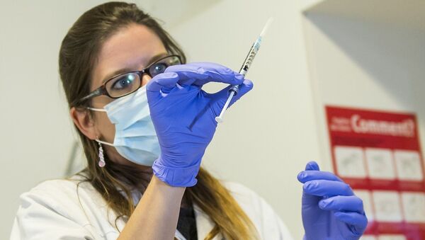 A nurse holds a dose of experimental vaccine - Sputnik International