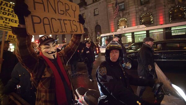 A demonstrator wearing a Guy Fawkes mask walks up 6th Ave as he protests against the police in the Manhattan borough of New York December 23, 2014 - Sputnik International