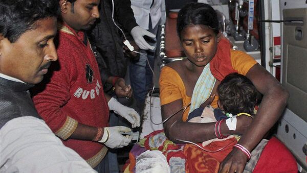 In this Tuesday, Dec. 23, 2014 photo, an injured woman and her child are carried in an ambulance to a local hospital in Sonitpur district in India's northeast state of Assam, India - Sputnik International