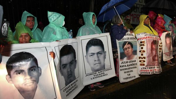 The relatives of 43 missing college students hold posters with images of their missing loved ones, as they protest their disappearance, at the Los Pinos presidential residence in Mexico City. - Sputnik International
