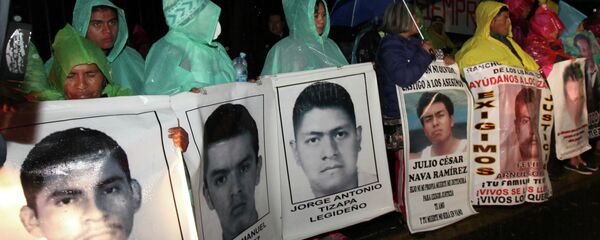 The relatives of 43 missing college students hold posters with images of their missing loved ones, as they protest their disappearance, at the Los Pinos presidential residence in Mexico City. - Sputnik International
