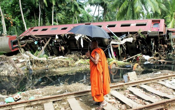 A Buddhist monk looks at a wrecked carriage after an entire train was destroyed by Sunday's tsunami in the town of Paraliya, 90 km (56 miles) south of Colombo, Sri Lanka - Sputnik International