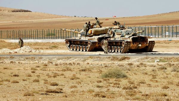 Turkish soldiers stand on top of tanks next to the Syrian-Trukish border fence - Sputnik International