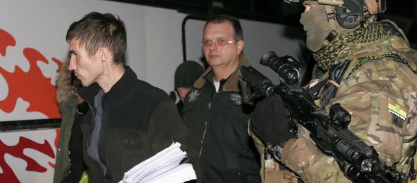 Members of independent supporters walk past a Ukrainian serviceman during an exchange of prisoners of war outside Donetsk Members of independent supporters walk past a Ukrainian serviceman during an exchange of prisoners of war outside Donetsk - Sputnik International