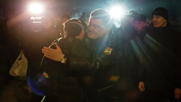 Ukraine's President Petro Poroshenko (C) greets a Ukrainian prisoner-of-war returning home after being exchanged for independence supporters, in Kiev. - Sputnik International
