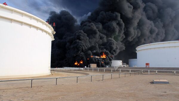 Smoke rises from an oil tank fire in Es Sider port December 26, 2014. A fire at an oil storage tank at Libya's Es Sider port has spread to two more tanks after a rocket hit the country's biggest terminal during clashes between forces allied to competing governments, officials said on Friday. - Sputnik International