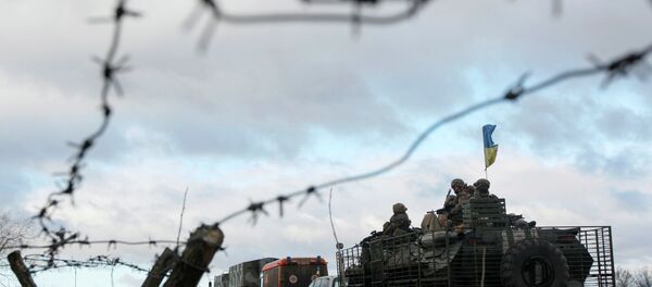 A Ukrainian military convoy is pictured through a barbed wire fence at a military base in the town of Kramatorsk, eastern Ukraine A Ukrainian military convoy is pictured through a barbed wire fence at a military base in the town of Kramatorsk, eastern Ukraine - Sputnik International