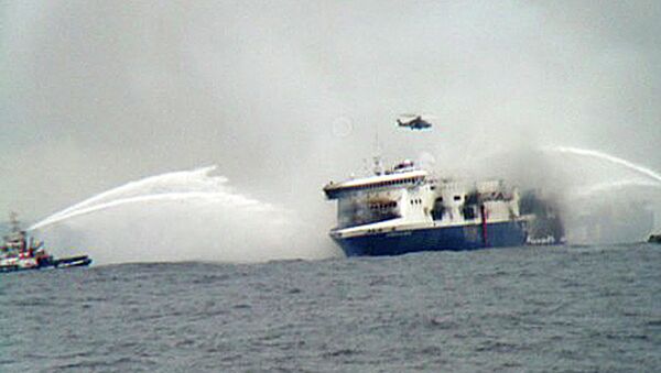 A rescue helicopter flies over the burning car ferry Norman Atlantic as fire fighting tug boats douche the vessel - Sputnik International