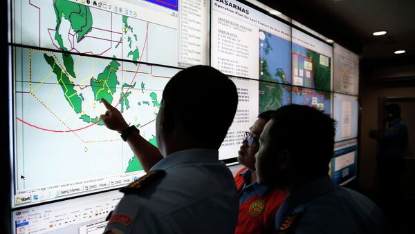 Military and rescue authorities monitor progress in the search for AirAsia Flight QZ8501 in the Mission Control Center inside the National Search and Rescue Agency in Jakarta December 29, 2014 - Sputnik International