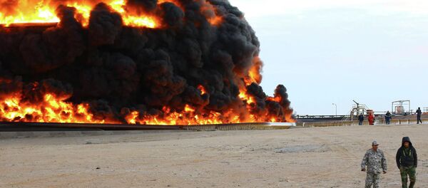 Firefighters try to put out the fire in an oil tank in Es Sider port December 26, 2014 - Sputnik International