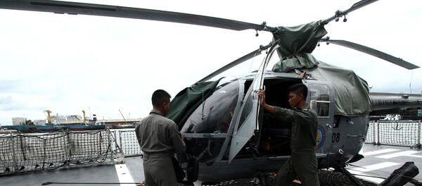 Navy soldiers check an helicopter on the deck of KRI Sultan Hasanuddin-366 warship before joining in search operations for AirAsia flight QZ8501 at Batuampar port in Batam, December 29, 2014 in this photo taken by Antara Foto - Sputnik International