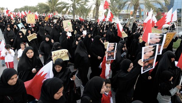 Protesters holding pictures of Al Waad President Ebrahim Shareef march during an anti-government rally organised by Bahrain's main opposition party, Al Wefaq in Budaiya west of Manama, December 26, 2014 - Sputnik International