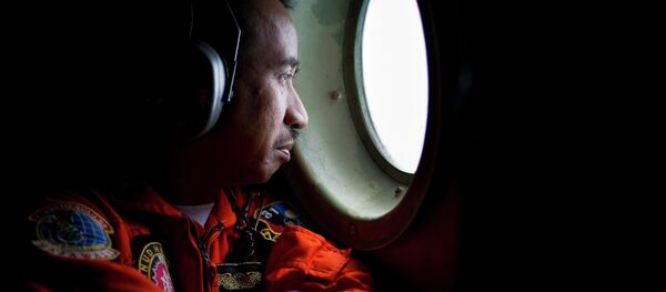 A member of an Indonesian Hercules C130 aircrew watches through a window while monitoring the Belitung Timur sea during search operations for AirAsia flight QZ8501 near Belitung island, December 29, 2014 A member of an Indonesian Hercules C130 aircrew watches through a window while monitoring the Belitung Timur sea during search operations for AirAsia flight QZ8501 near Belitung island, December 29, 2014 - Sputnik International