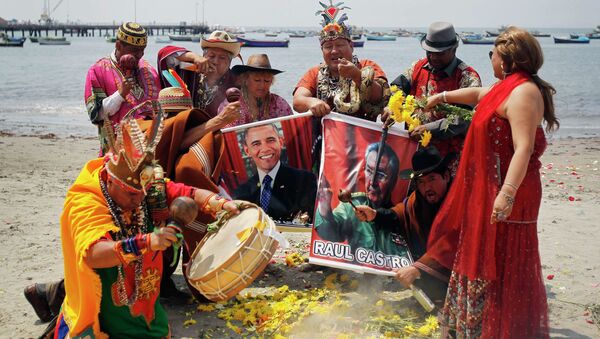 Shamans holding posters of U.S. President Barack Obama and Cuba's President Raul Castro, perform a ritual of predictions for the new year at Agua Dulce beach in Lima December 29, 2014 - Sputnik International