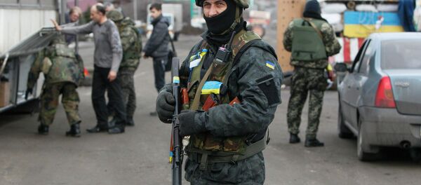 Ukrainian serviceman guards as his comrades check a civilian transport near the eastern Ukrainian town of Debaltseve in Donetsk region, December 24, 2014 Ukrainian serviceman guards as his comrades check a civilian transport near the eastern Ukrainian town of Debaltseve in Donetsk region, December 24, 2014 - Sputnik International