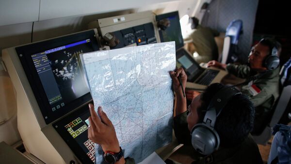 A crew member on an Indonesian Maritime Surveillance plane checks a map during a search for AirAsia's Flight QZ8501 north of Bangka island December 30, 2014 - Sputnik International