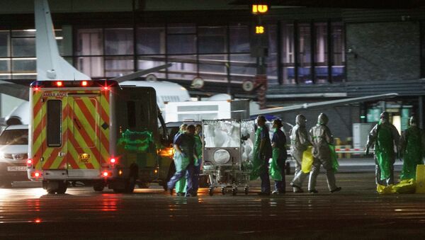 An Ebola patient is transferred on to a Hercules transport plane at Glasgow Airport in Scotland December 30, 2014, to be transported to London - Sputnik International