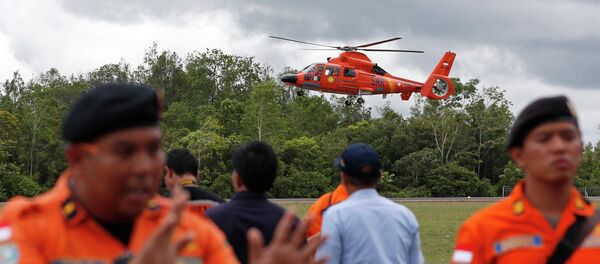 An Indonesian Search and Rescue helicopter carrying the bodies of two AirAsia passengers recovered from the sea prepares to land at the airport in Pangkalan Bun, Central Kalimantan, December 31, 2014 - Sputnik International