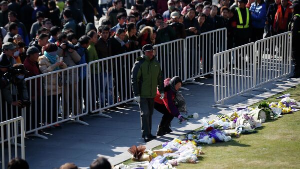 People lay down flowers during a memorial ceremony in memory of people who were killed in a stampede incident during a New Year's celebration on the Bund, in Shanghai January 1, 2015 - Sputnik International