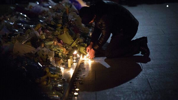 A man lights candles during a memorial ceremony - Sputnik International
