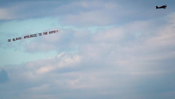 An airplane towing a banner reading de Blasio, apologize to the NYPD flies over the Hudson River in New York - Sputnik International