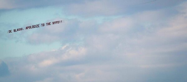An airplane towing a banner reading de Blasio, apologize to the NYPD flies over the Hudson River in New York An airplane towing a banner reading de Blasio, apologize to the NYPD flies over the Hudson River in New York - Sputnik International