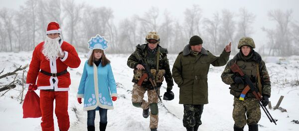 Local residents dressed as Father Frost, an equivalent of Santa Claus, and his granddaughter Snegurochka (Snow-Maiden), walk with servicemen as they visit check points of the Ukrainian army and self-defence units to congratulate the military with the coming of a New Year, near Lysychansk, Luhansk region, January 2, 2015. - Sputnik International