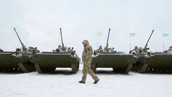 A Ukrainian serviceman walks past reconditioned armoured personnel carriers (APCs) - Sputnik International