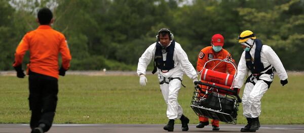 Rescue team members carry the dead body of a passenger of AirAsia flight QZ8501 Rescue team members carry the dead body of a passenger of AirAsia flight QZ8501 - Sputnik International