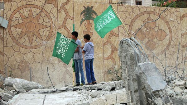Palestinians raise Islamist Hamas movement flags on the top of what remains of the house of Hussam Qawasmeh - Sputnik International