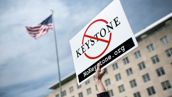 An activist holds up a sign outside the State Department during a protest of the Keystone XL pipeline on March 7, 2014 in Washington - Sputnik International