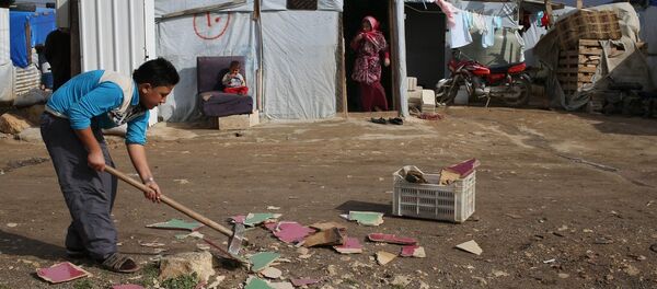A Syrian boy chops scrap wood outside of his tent in preparation for the possibility of a snow storm at a refugee camp in Deir Zannoun village, Bekaa valley, Lebanon, Tuesday, Jan. 6, 2015 A Syrian boy chops scrap wood outside of his tent in preparation for the possibility of a snow storm at a refugee camp in Deir Zannoun village, Bekaa valley, Lebanon, Tuesday, Jan. 6, 2015 - Sputnik International