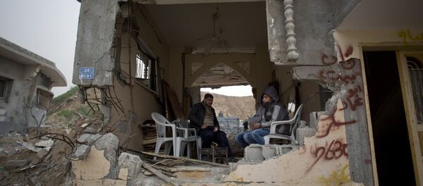 Palestinians sit in a room of their war-damaged house in the Shijaiyah neighborhood of Gaza City, Tuesday, Jan. 6, 2015 Palestinians sit in a room of their war-damaged house in the Shijaiyah neighborhood of Gaza City, Tuesday, Jan. 6, 2015 - Sputnik International